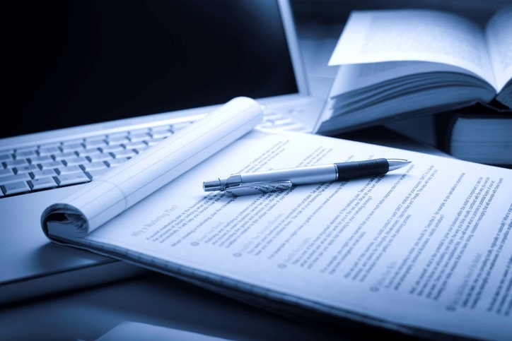 Laptop computer with books, pen and legal pad