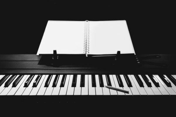 piano keyboard with notebook and pencil