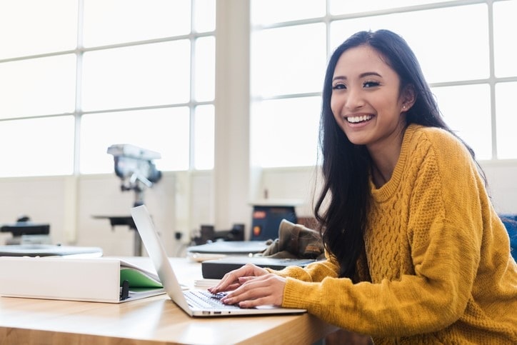 smiling student using laptop