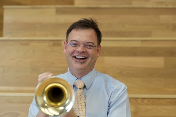 Dusty Molyneaux headshot 2023 with trumpet