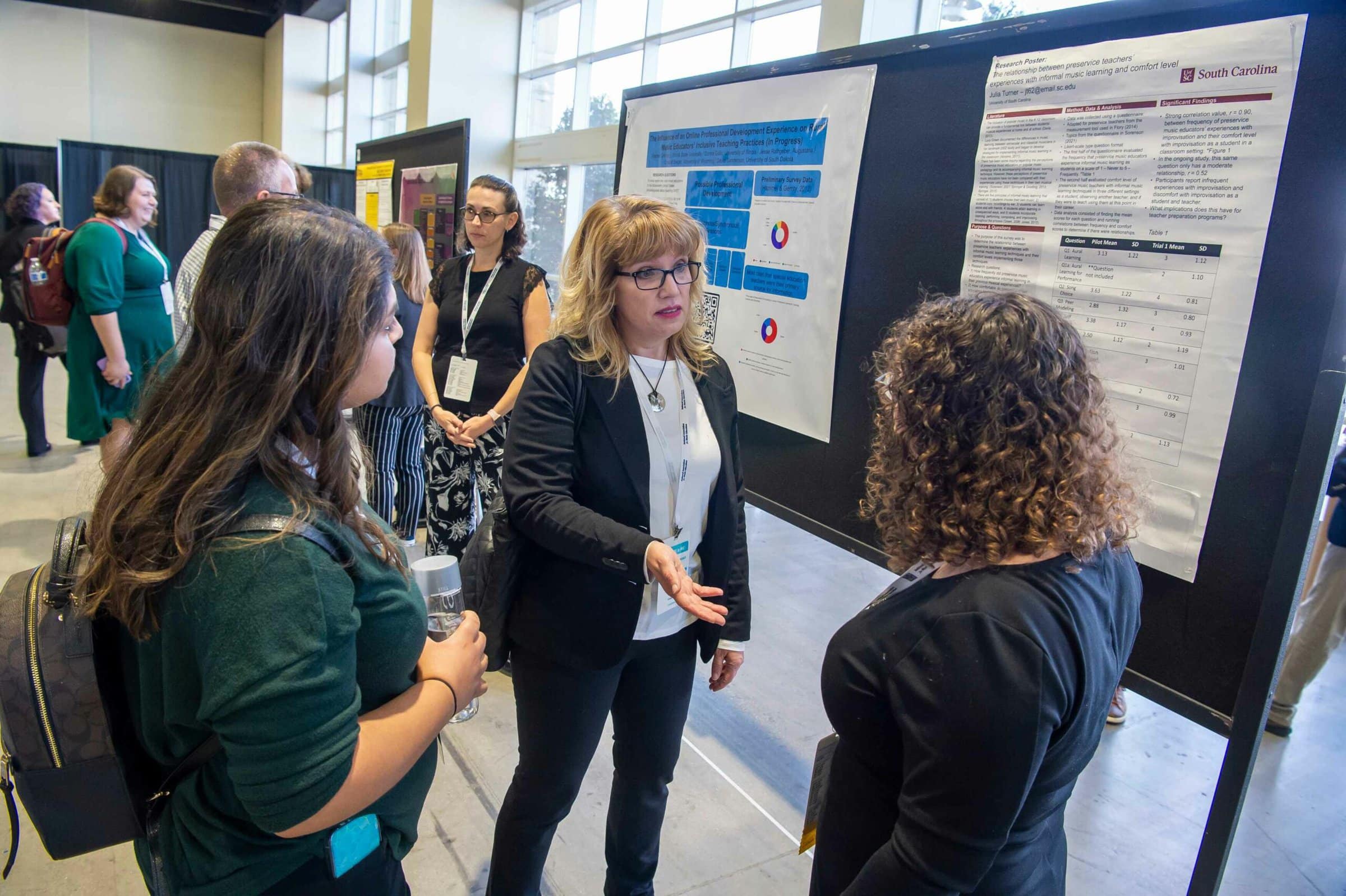 music research poster presentation setting with three women in conversation