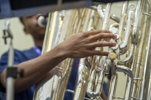 closeup of high school student playing brass instrument tuba