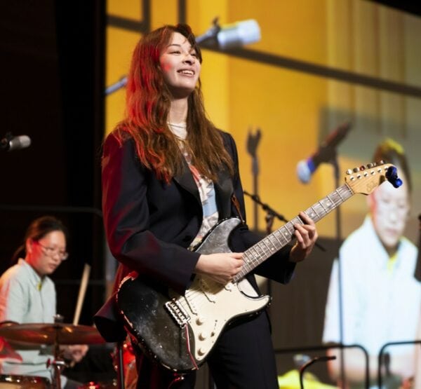 Student Playing Guitar with Band