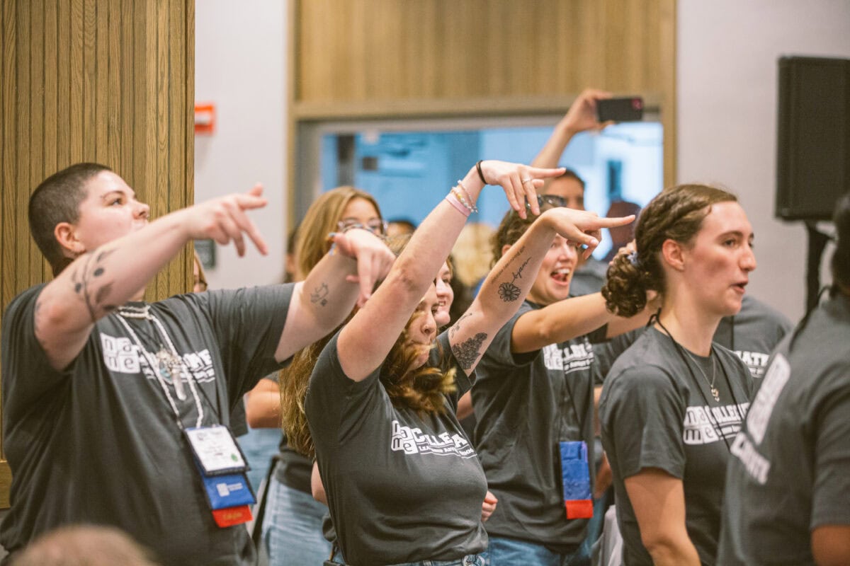 excited collegiates with arms raised at Collegiate Leadership Advocacy Summit 2024