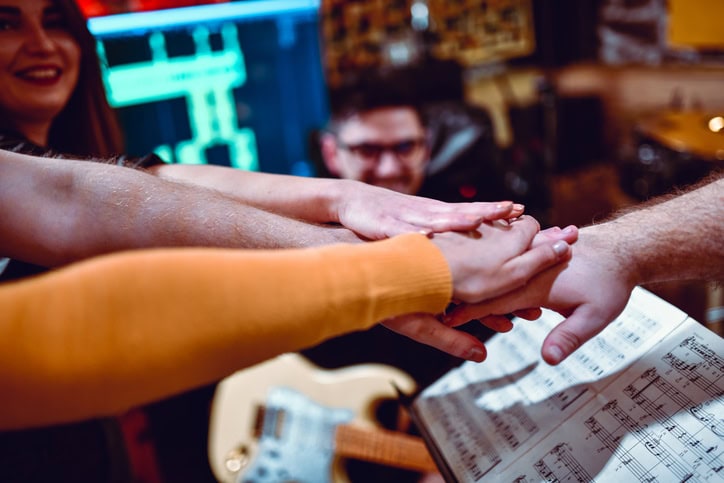 Band members stacking their hands in a circle