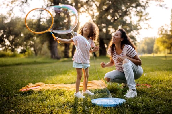 Elementary aged girl playing with mother in a public park