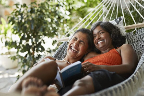 mother and adolescent daughter in a hammock laughing
