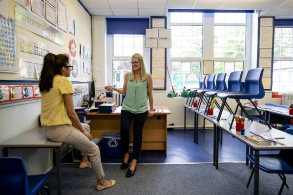 Teachers in an empty classroom lesson planning