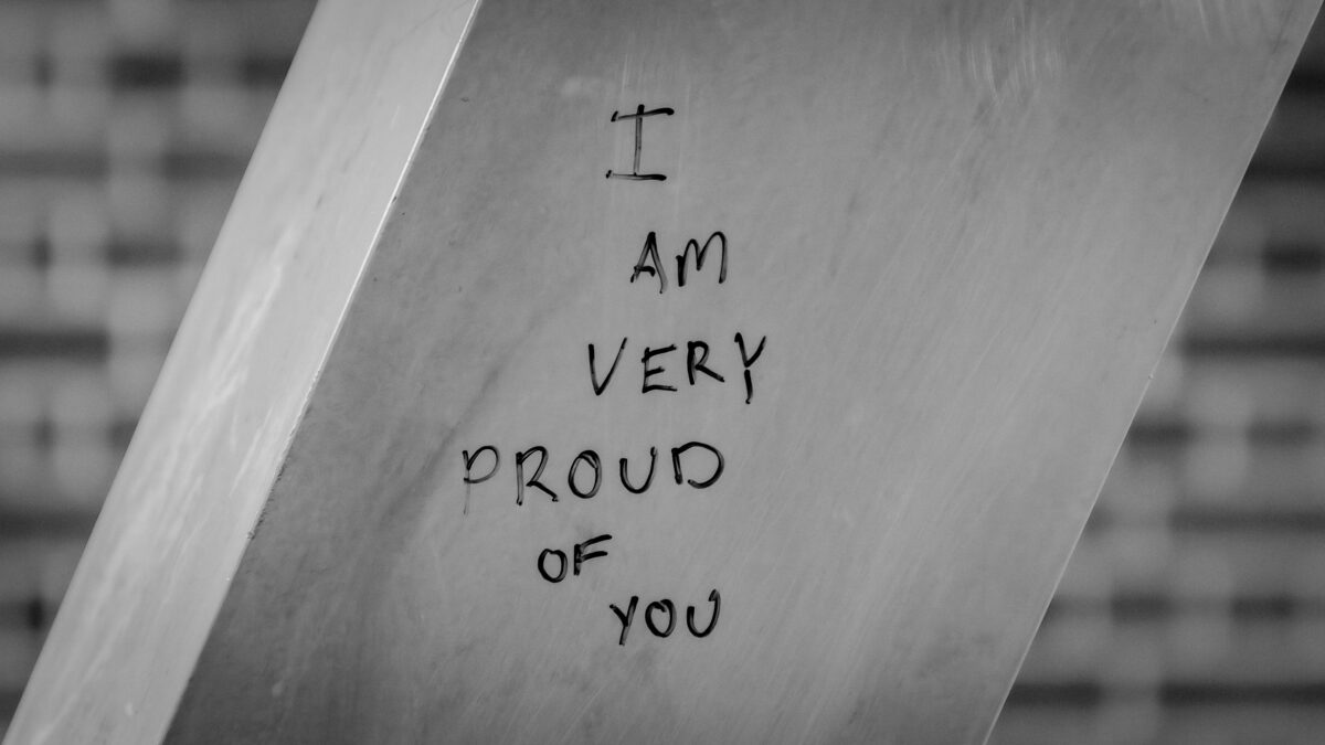 words I am very proud of you in black marker on a metal post