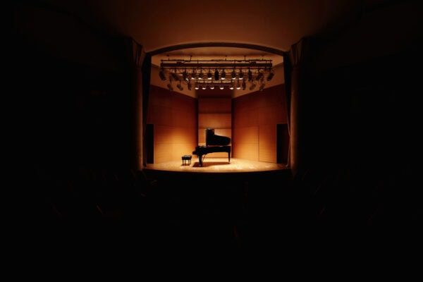 centered grand piano on stage in concert hall