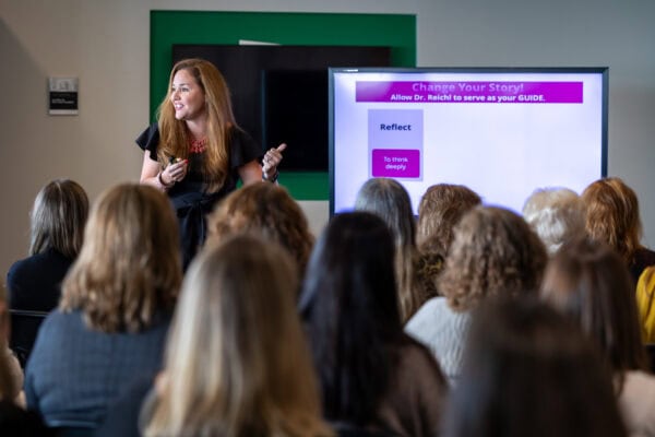 Lori Schwartz Reichl at head of room speaking with veteran educators