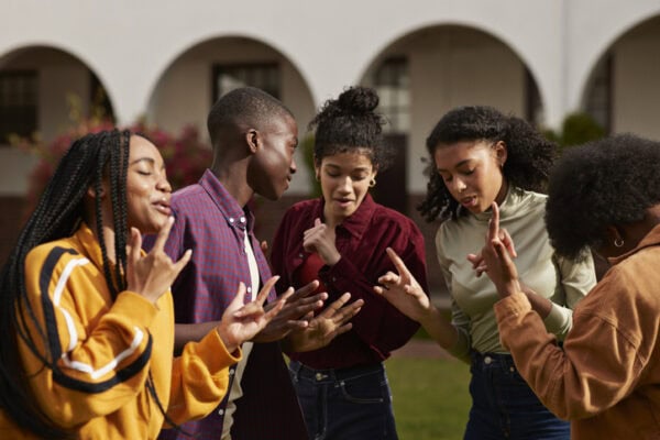 Happy friends dancing together at campus enjoying break