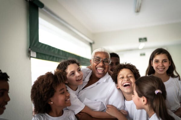 Portrait of a happy group of elementary students with smiling teacher