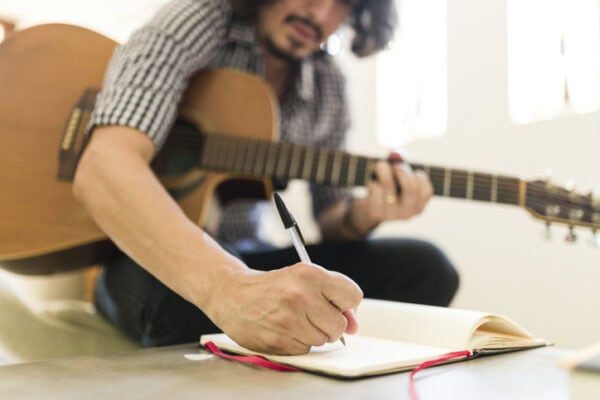 Man playing guitar and composing