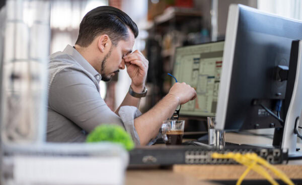 Stressed male teacher at computer