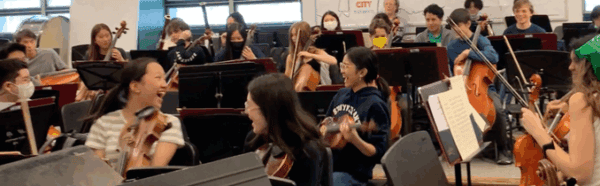 laughing students in orchestra rehearsal