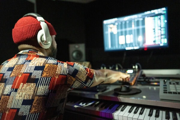 Rear view of a producer man using a sound mixer in the recording studio