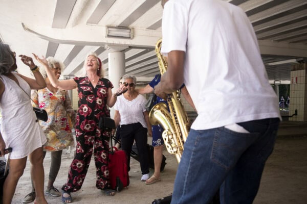 Senior women enjoying street musician's saxophone music