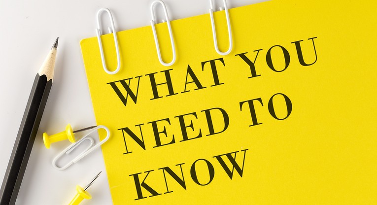 WHAT YOU NEED TO NOW word on yellow paper with office tools on a white background