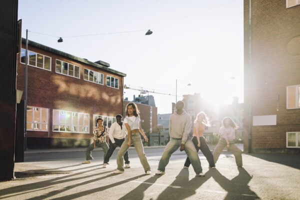 Multiracial male and female dancers dancing on campus at sunny day
