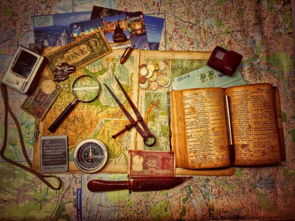 collage of treasure hunt items like a compass, journal, map, money, magnifying glass, recording device, and other items