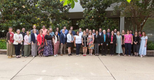 Group photo of the Advocacy Leadership Force standing together in a plaza surrounded by greenery
