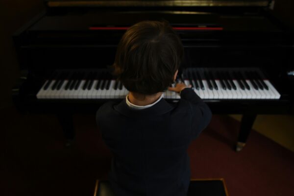 view from behind young boy at piano
