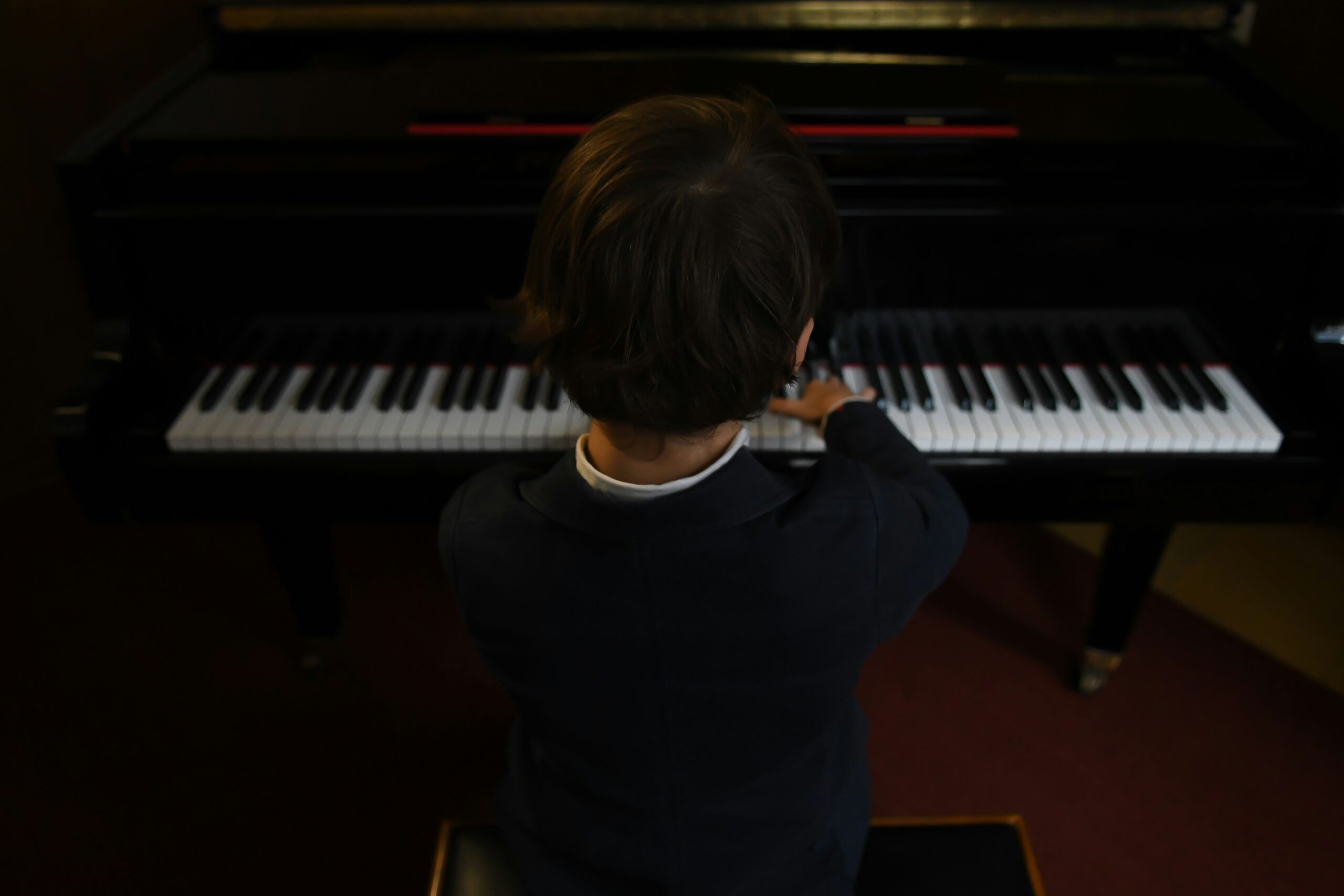view from behind young boy at piano