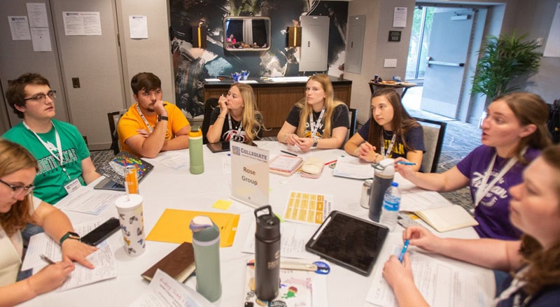 Collegiate students discussing materials at a table at Collegiate Leadership Advocacy Summit