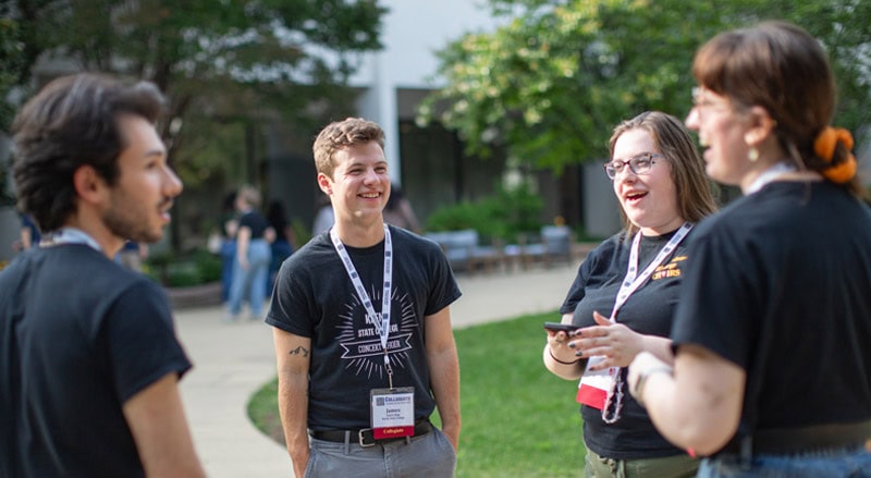Four college students standing and talking to each other