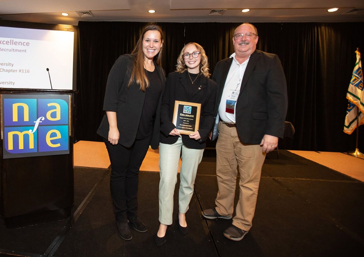 NAfME Collegiate Professional Achievement Award recipient Maria Hisey accepts plaque from Steve Kelly and Kati Cox at 2025 NAfME National Assembly