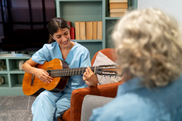 nurse playing guitar for patient