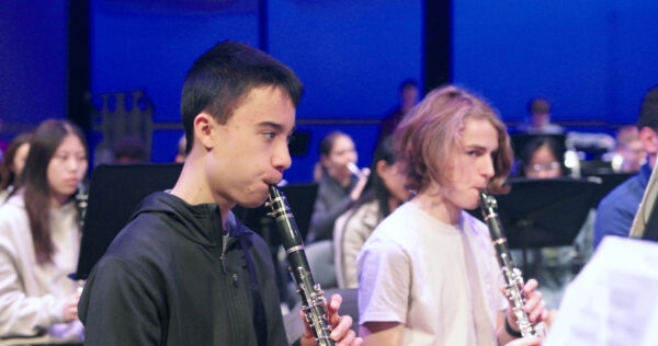 high school ensemble students rehearsing on stage