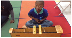 student with glockenspiel looking at camera