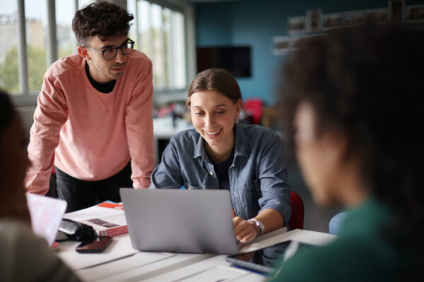 A group of students working together around a table in class at college