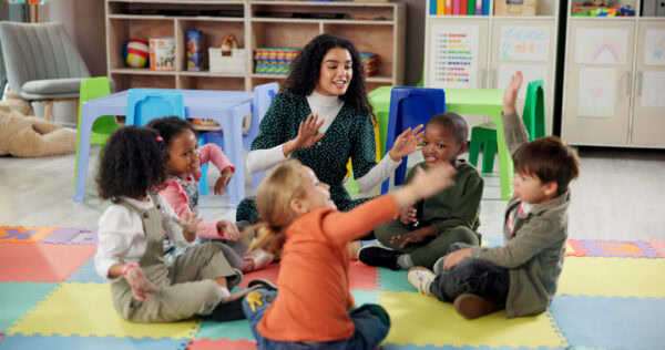 Singing, students and teacher in classroom sitting in circle.