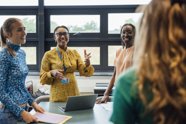 four teachers meeting and planning in a school office