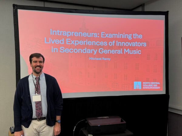 Attendee in front of a presentation titled Intrapreneurs: Examining the Lived Experiences of Innovators in Secondary General Music - Michael Remy