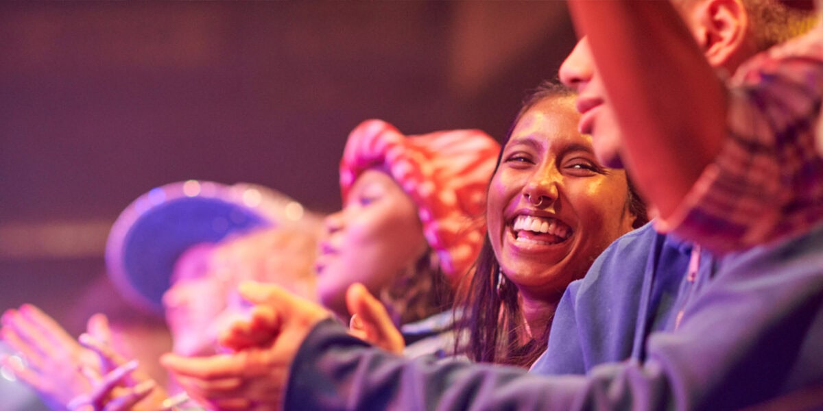 concert audience members smiling and applauding