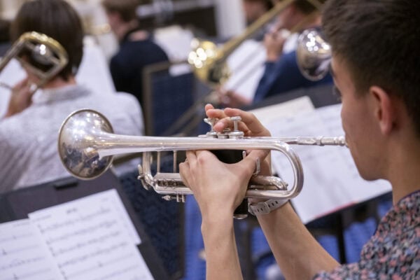 closeup of student trumpet player in rehearsal in front of music stand with sheet music